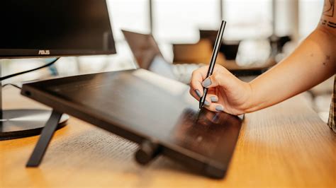 Une vue d'ensemble de l'écran Wacom Cintiq avec le stylet posé à côté, mettant en évidence sa surface de travail.