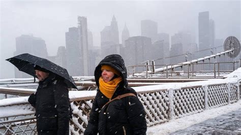 Couple sous un parapluie durant une tempête de neige à New York