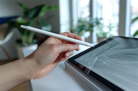 Illustration montrant comment retirer et nettoyer la pointe d'un stylet de tablette graphique