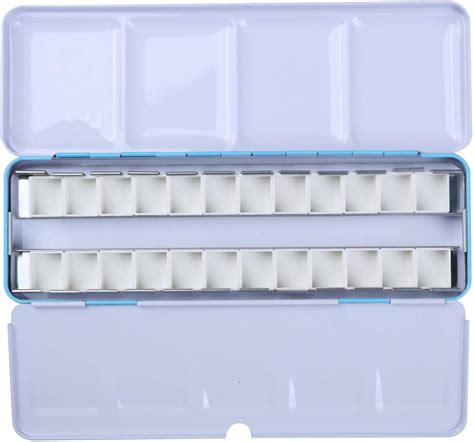 Gros plan sur une palette d'aquarelle vide avec des demi-godets en attente d'être remplis