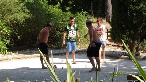 Personnes jouant au volley-ball et à la pétanque au camping