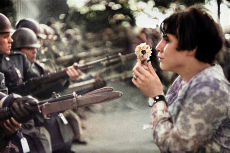 Photographie de Jan Rose Kasmir offrant une fleur aux soldats pendant la manifestation contre la guerre du Vietnam