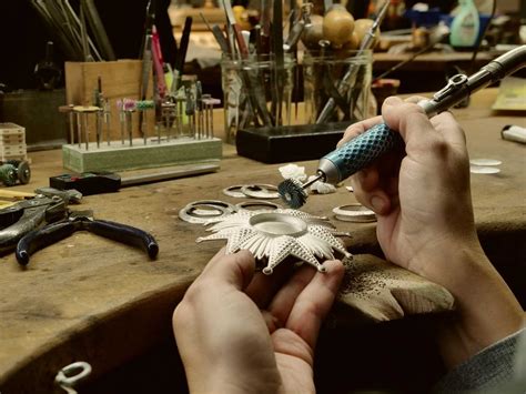 Illustration d'un atelier d'orfèvrerie traditionnel avec des outils et des pièces en argent.
