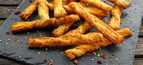 Photographie de bâtonnets de fromage croustillants ressemblant à des frites, servis avec des verrines de confitures.